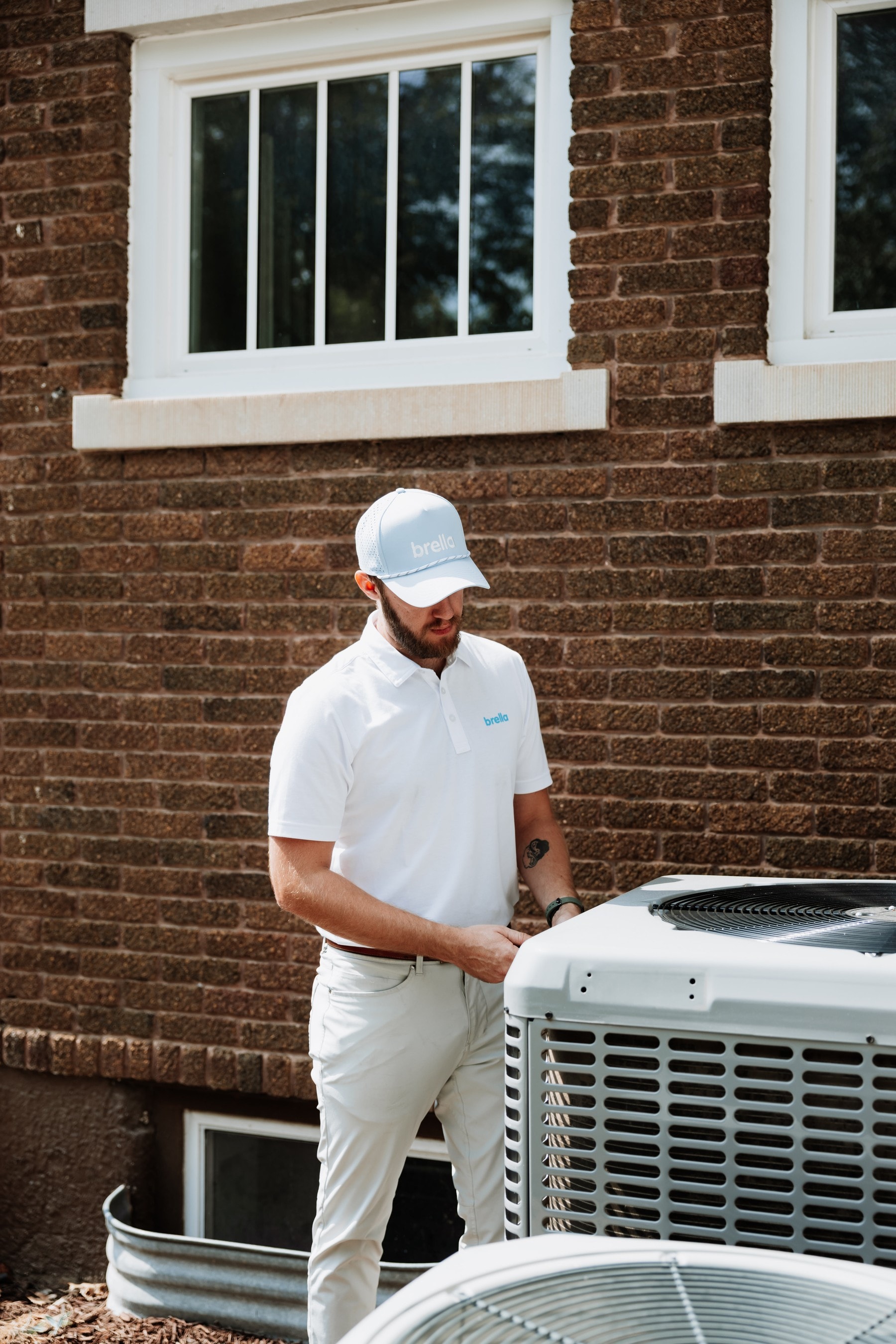 A Brella technician inspecting an outdoor A/C condenser
